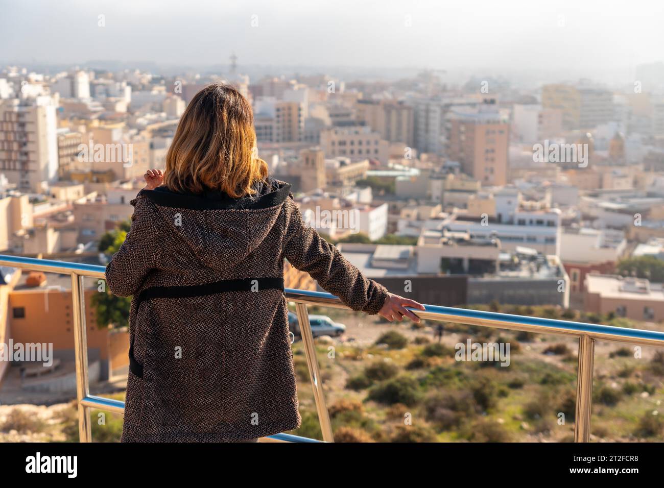 Una giovane ragazza turistica che guarda la città dal punto di vista di Cerro San Cristobal nella città di Almeria, Andalusia. Spagna. Costa del sol nel Foto Stock