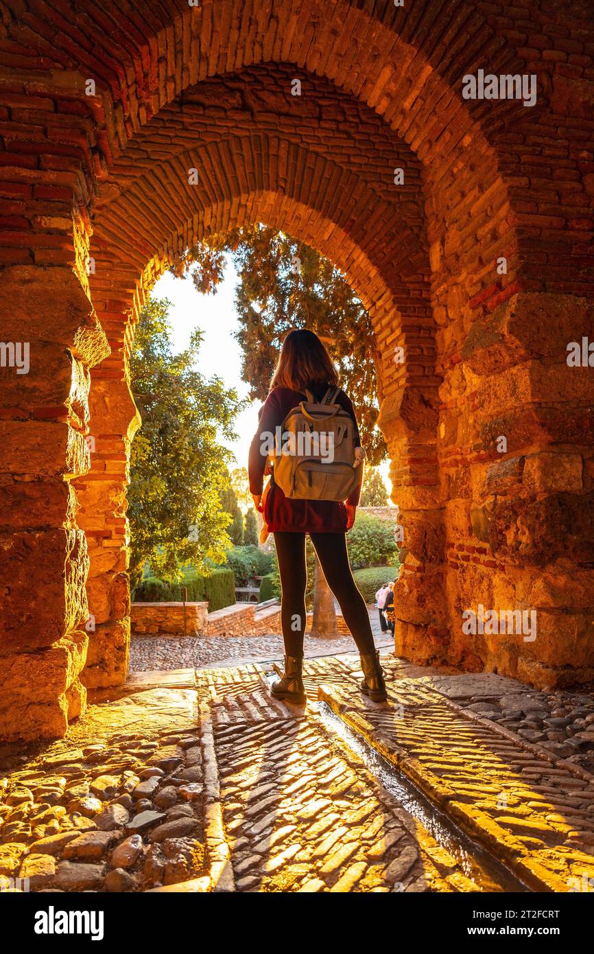 Un turista al tramonto alla porta delle mura dell'Alcazaba nella città di Malaga, Andalusia. Spagna. Fortezza medievale in stile arabo Foto Stock