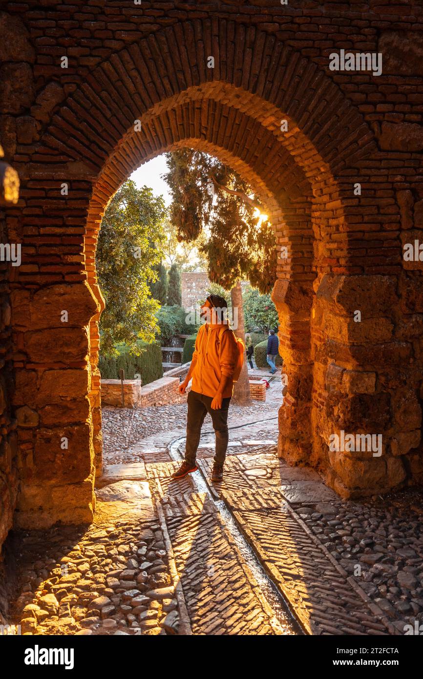 Una passeggiata turistica al tramonto presso la porta delle mura dell'Alcazaba nella città di Malaga, Andalusia. Spagna. Fortezza medievale in stile arabo Foto Stock