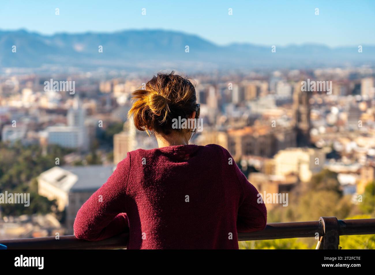 Una giovane donna che guarda la vista della città e della Cattedrale dell'Incarnazione di Malaga dal Castillo de Gibralfaro nella città di Malaga Foto Stock