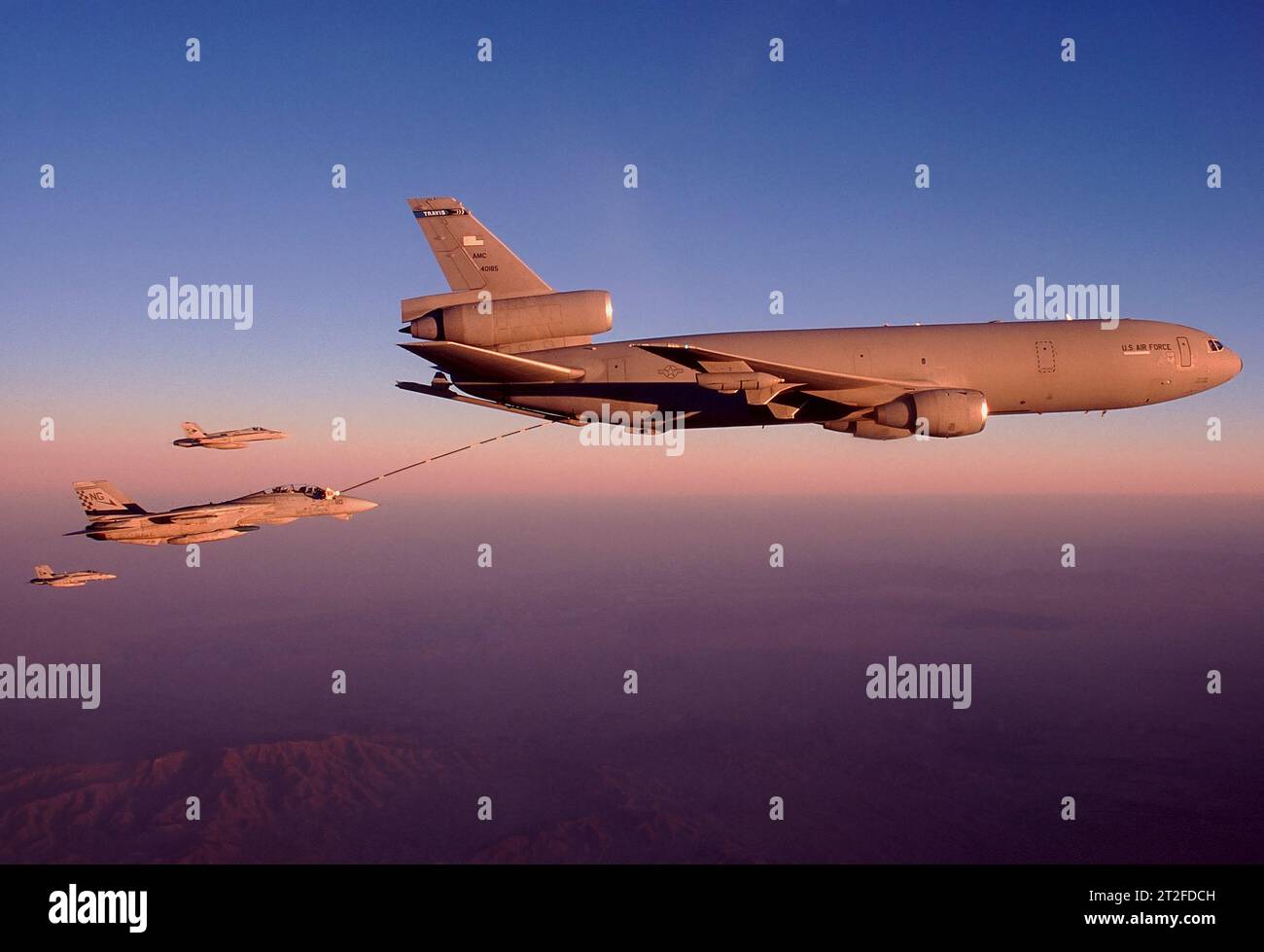Gli F-14 e gli F/A-18 si riforniscono di carburante da un KC-10 la sera sopra la California. Foto Stock