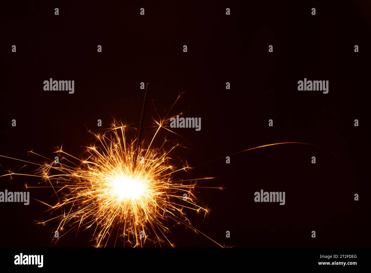 Foto uno sfondo nero prepara il palcoscenico per festeggiare, dove la scintilla luminosa di uno sparkler ardente, adornato con il testo "Natale", assomiglia Foto Stock