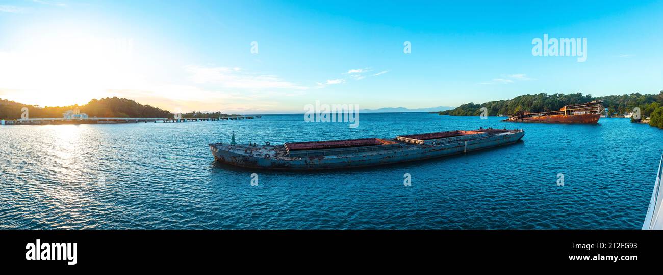 Vista panoramica della barca abbandonata nel porto di Roatan all'alba. Honduras Foto Stock
