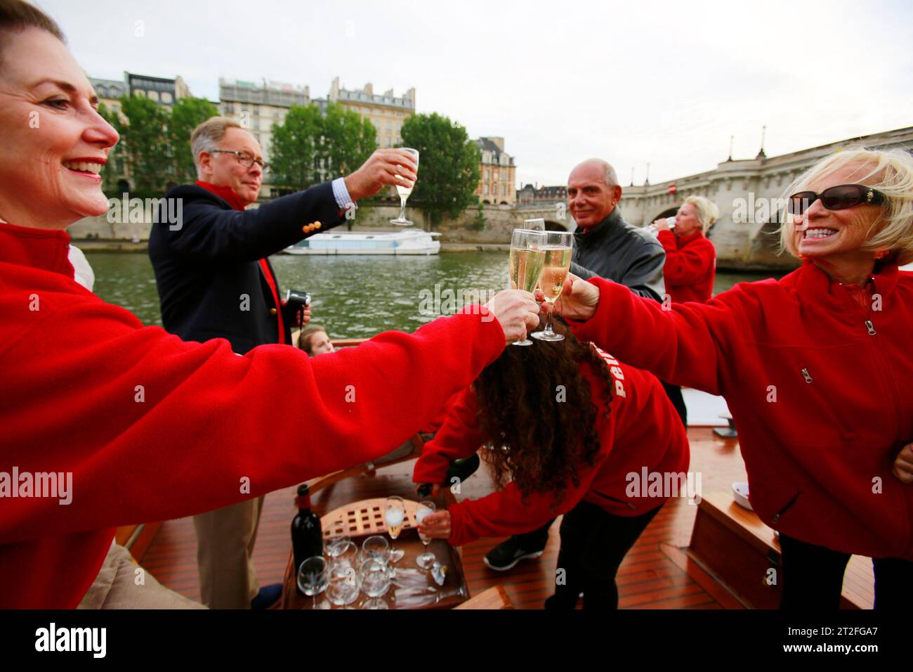 Una famiglia e gli amici stanno bevendo un bicchiere di champagne sulla barca sulla Senna a Parigi Foto Stock