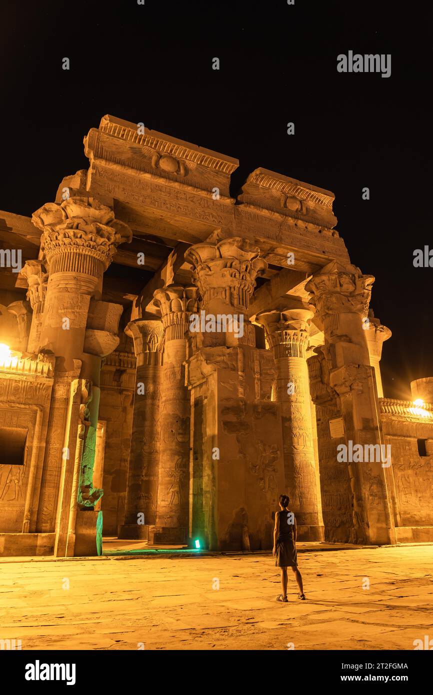 Una giovane donna che visita di notte il bellissimo tempio di Kom Ombo, il tempio dedicato agli dei Sobek e Horus. Nella città di Kom Ombo vicino Foto Stock