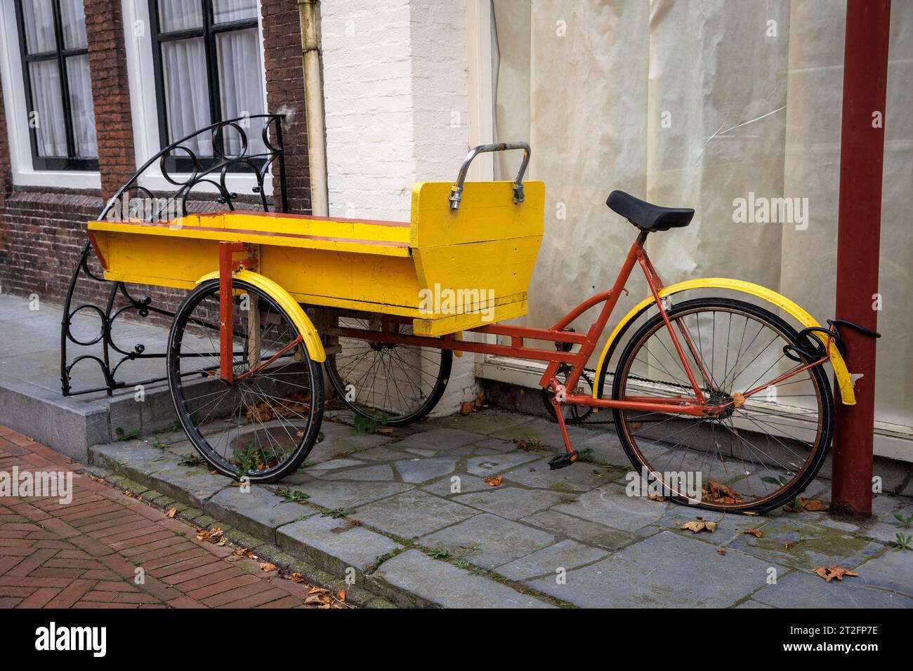 La vecchia bici da carico si trova di fronte a una casa a Zierikzee sulla penisola Schouwen-Duiveland, Zelanda, Paesi Bassi. altes Lastenfahrrad steht vor einem Foto Stock