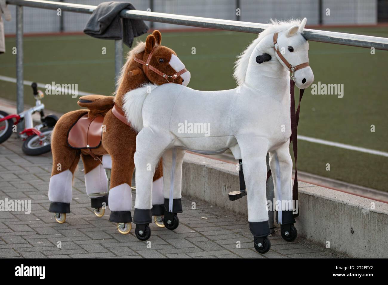 cavalli giocattolo su cui sedersi in un campo sportivo Foto Stock