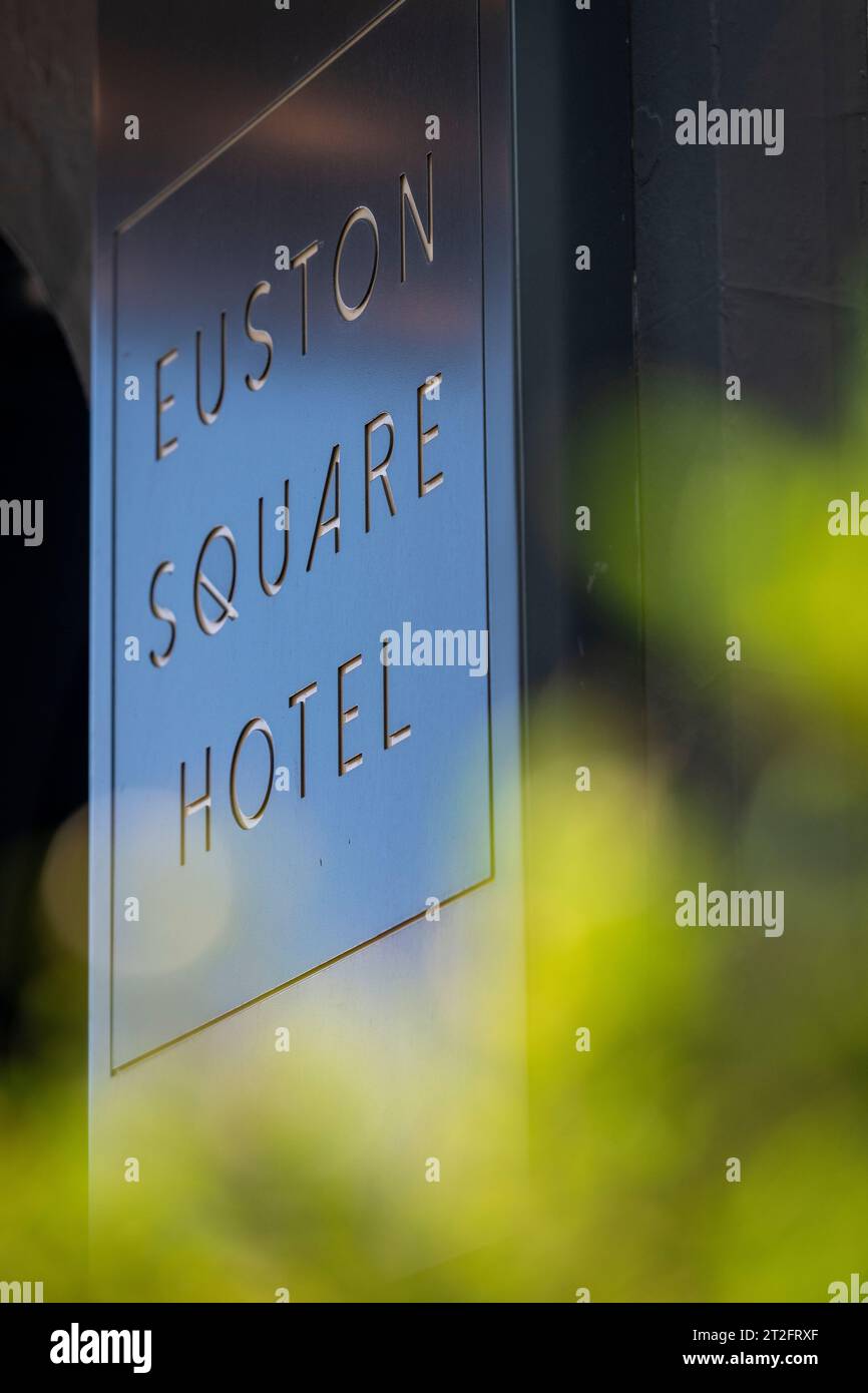 Marchio Euston Square Hotel sulla parete esterna dietro un morbido fogliame in primo piano. Solo per uso editoriale. Foto Stock