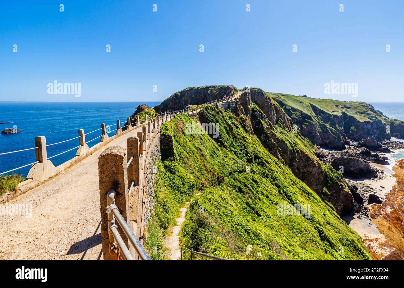 La Coupee, uno stretto istmo con la strada che collega la grande Sark a Little Sark, Sark, Isole del Canale in una soleggiata tarda primavera/inizio estate Foto Stock