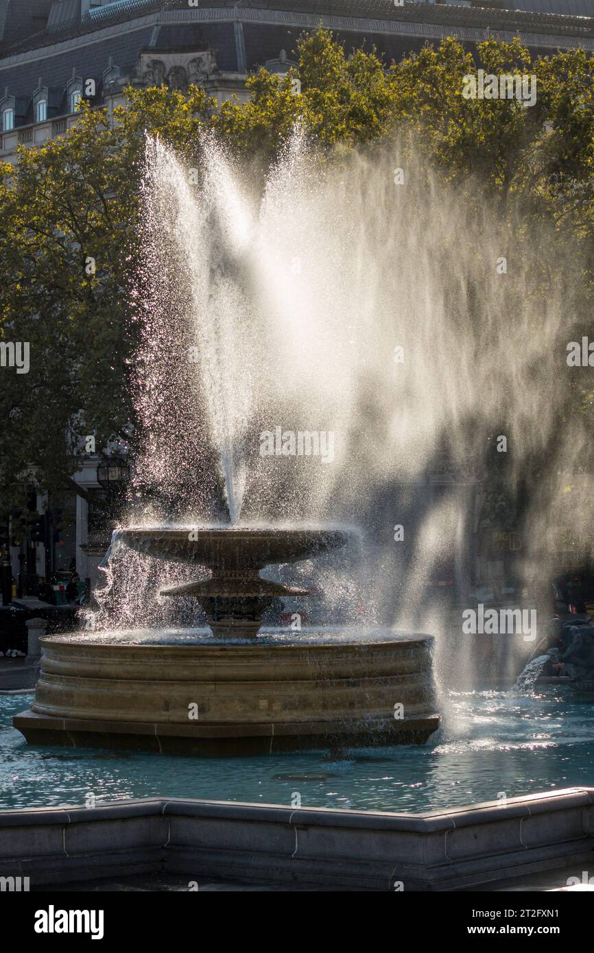 Una delle fontane di Trafalgar Square, Londra, in una ventosa giornata autunnale Foto Stock