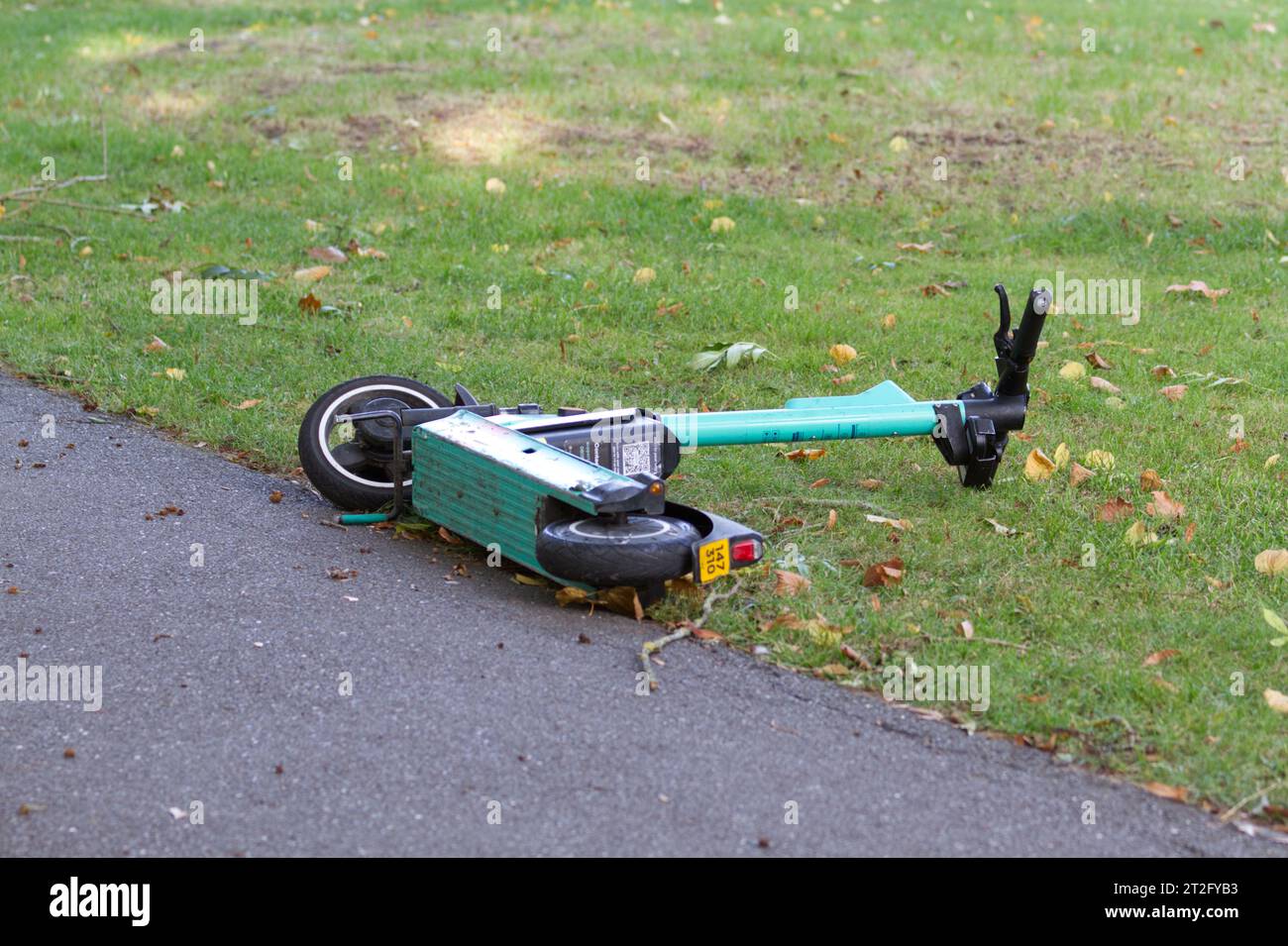 Scooter elettrico o e-scooter gettati e sdraiati a terra. Foto Stock