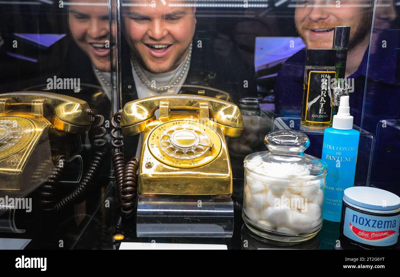 Londra, Regno Unito. 19 ottobre 2023. Un visitatore guarda il "Gold Telephone", un telefono placcato oro dalla camera di Elvis al piano superiore a Graceland. La mostra "Direct from Graceland: Elvis" presenta oltre 400 manufatti e oggetti iconici di proprietà di Elvis, direttamente dalla casa di Graceland dell'icona a Memphis, Tennessee. La mostra si apre il 20 ottobre presso l'Arches London Bridge in Bermondsey Street. Crediti: Imageplotter/Alamy Live News Foto Stock