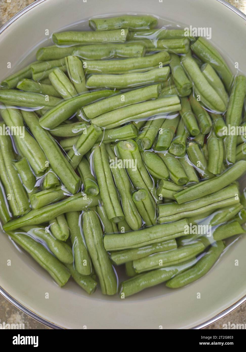 pulizia dei fagioli verdi tagliati con acqua, detti fagioli francesi o fagiolini o chiocciole, verdure preparate per la cottura in un recipiente, prelevate direttamente dall'alto Foto Stock