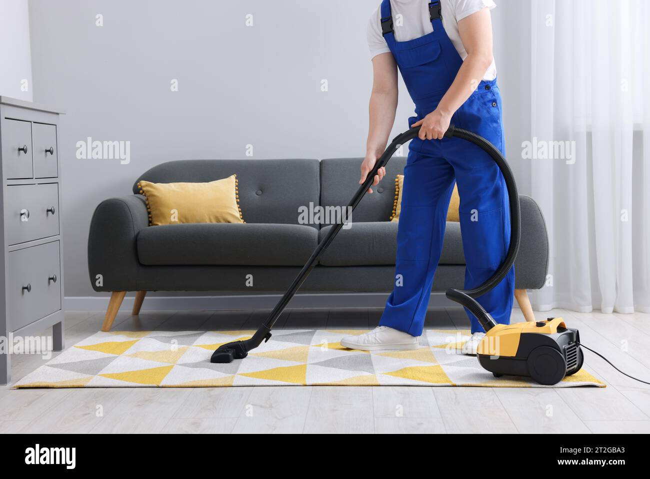 Pulitori professionali in uniforme blu il lavaggio di pavimenti e mobili di  tergitura in white hotel appartamento o camera da letto. Il servizio di  pulizia concept Foto stock - Alamy