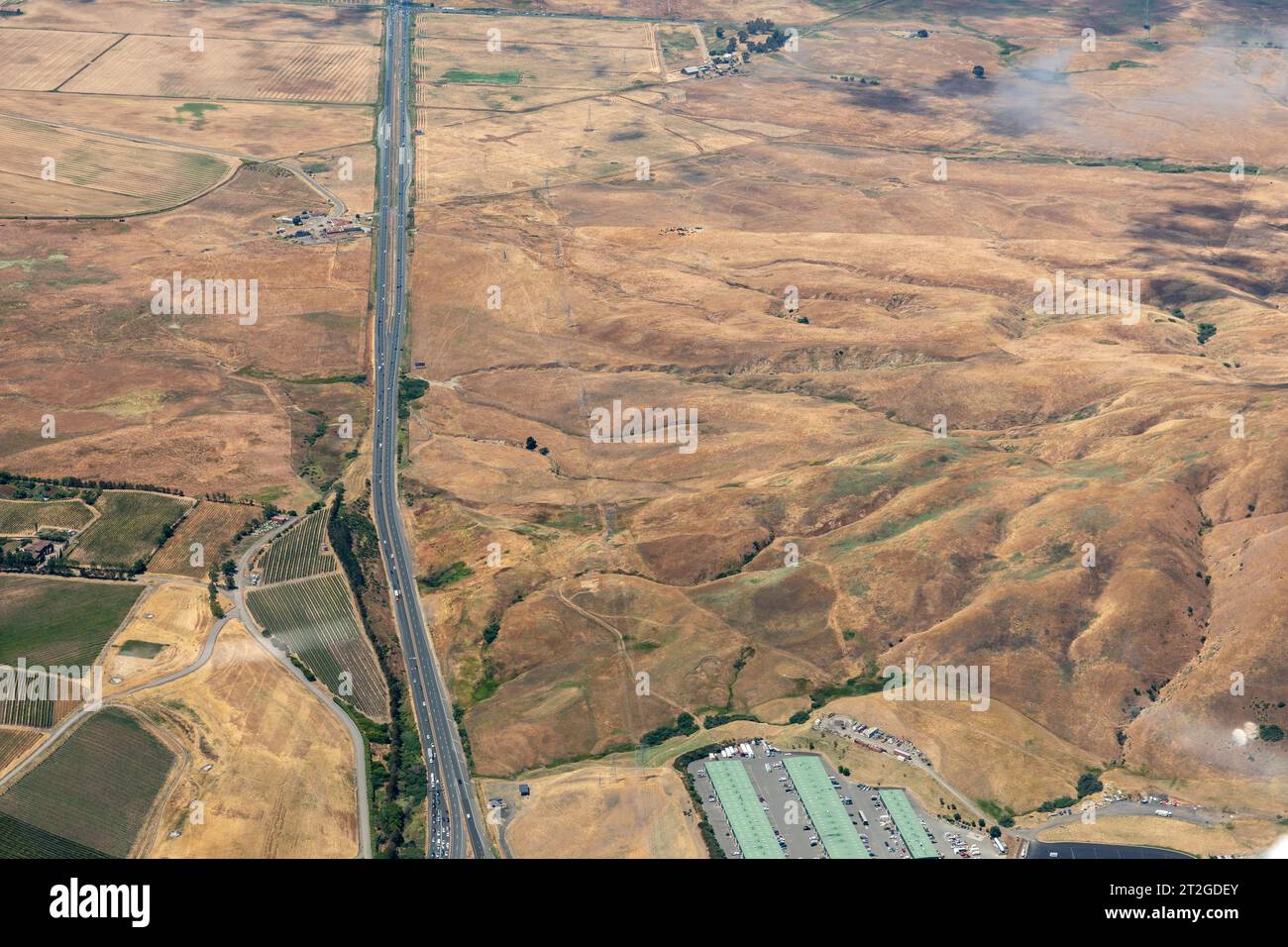 Vista aerea del taglio stradale attraverso le praterie asciutte della California settentrionale Foto Stock
