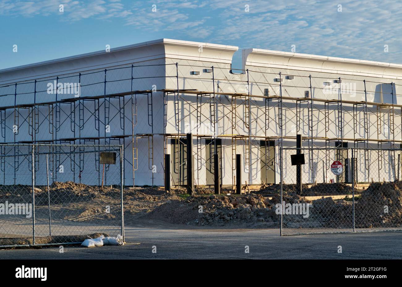 Houston, Texas USA 08-30-2023: Costruzione in corso di un edificio generico a più piani con ponteggi e recinzione di sicurezza. Foto Stock