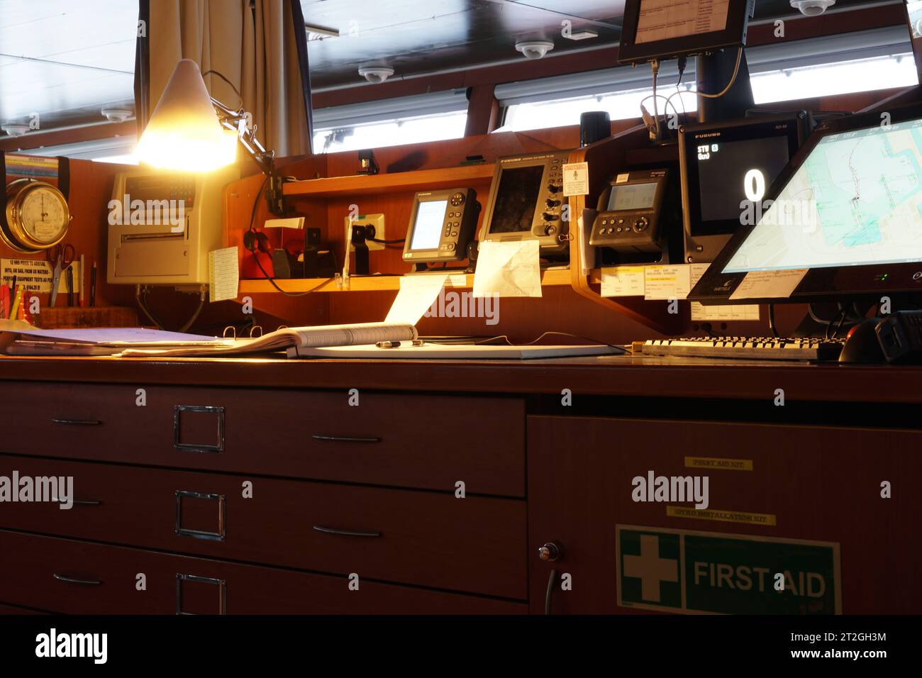 Apparecchiature elettroniche di navigazione e giornale di bordo su tavola di navigazione situato sul ponte della nave portacontainer. Foto Stock