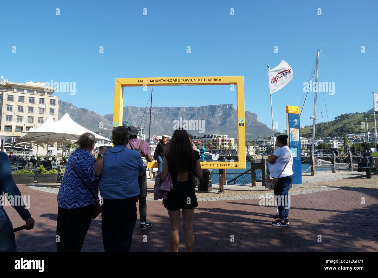 Cornice turistica gialla con Table Mountain sul lungomare con molti turisti in attesa di scattare foto. Foto Stock