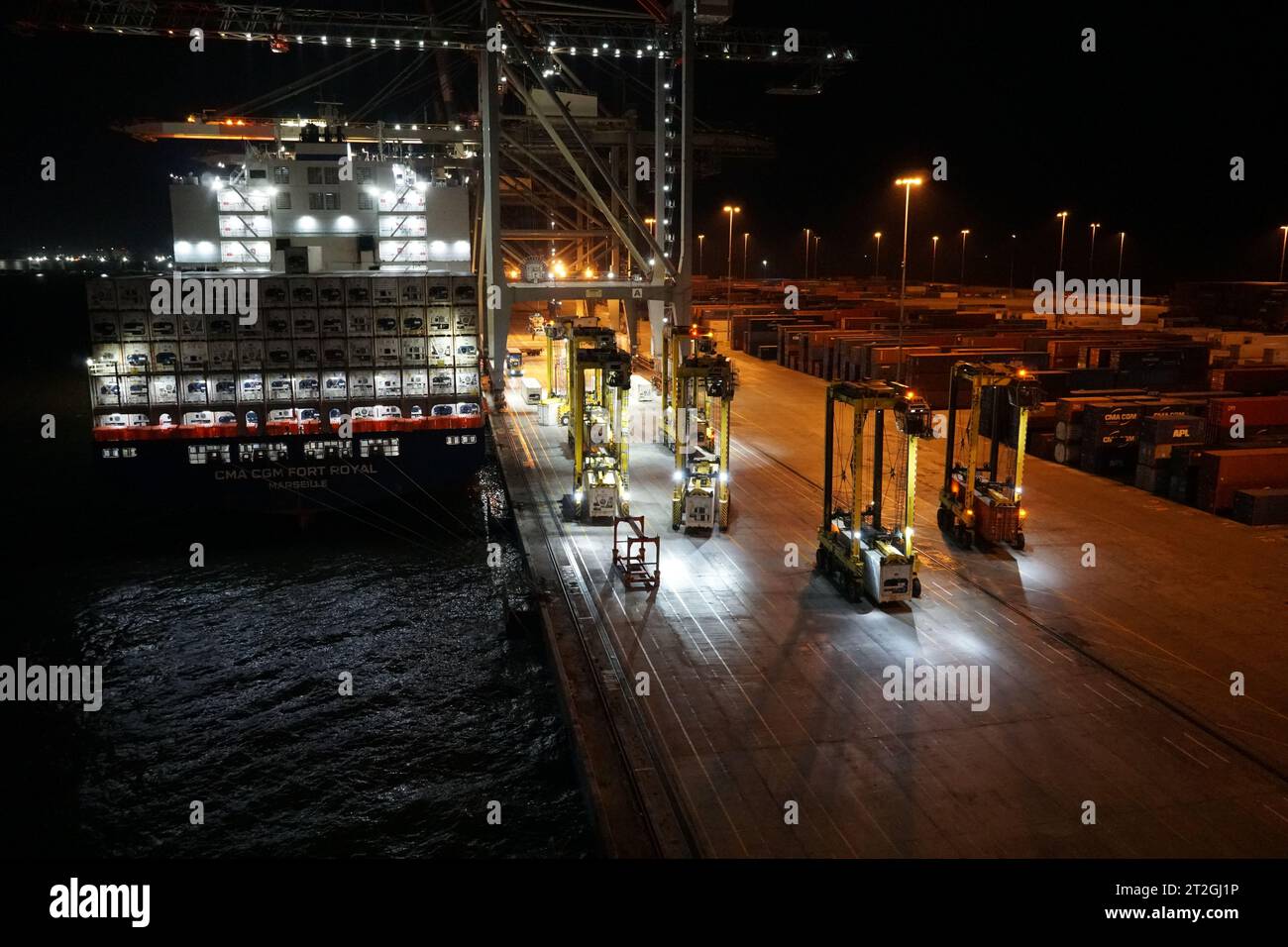 Navi portacontainer sotto carico con gru a cavalletto durante la notte nel porto di Kingston. Foto Stock