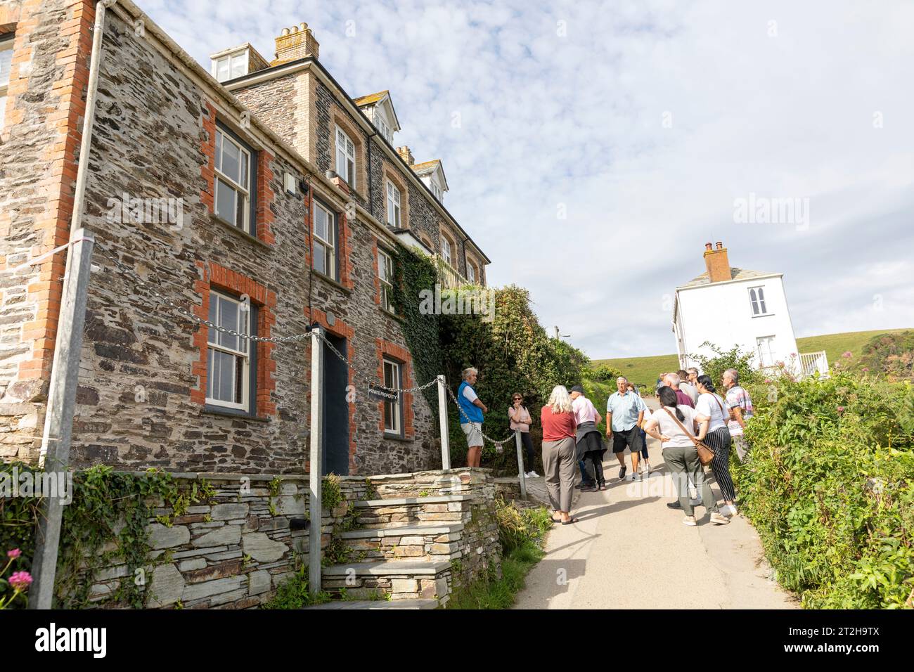 Port Isaac Cornovaglia, i visitatori in un tour a piedi di Doc Martin che mostra il villaggio dove è stata girata la serie televisiva, Inghilterra, Regno Unito, 2023 Foto Stock