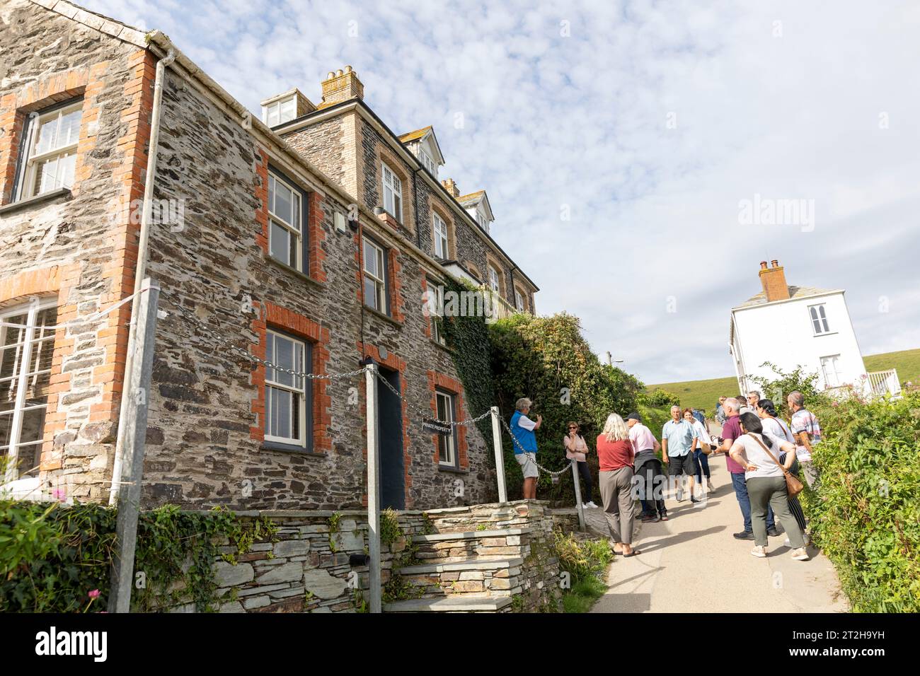 Port Isaac Cornovaglia, i visitatori in un tour a piedi di Doc Martin che mostra il villaggio dove è stata girata la serie televisiva, Inghilterra, Regno Unito, 2023 Foto Stock