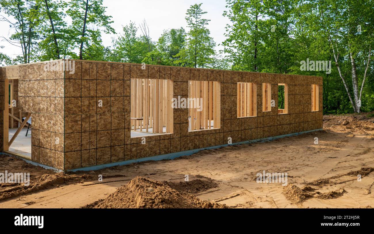 Nuova costruzione di abitazioni nelle prime fasi, con pareti esterne e aperture per finestre future. Foto Stock