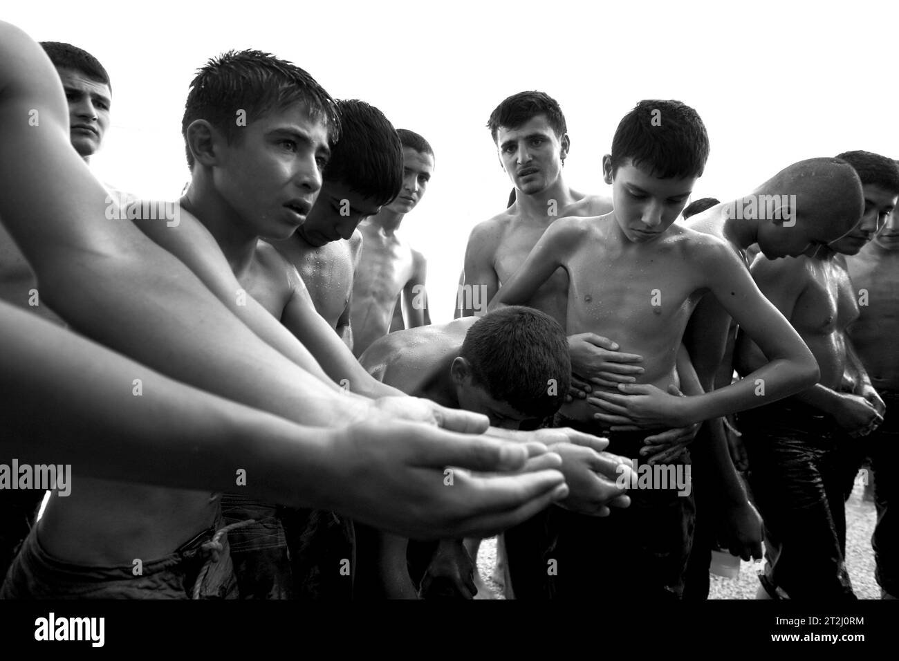 I lottatori turchi a olio applicano olio d'oliva ai loro corpi prima dell'inizio della competizione all'Elmali Turkish Oil Wrestling Festival. Foto Stock