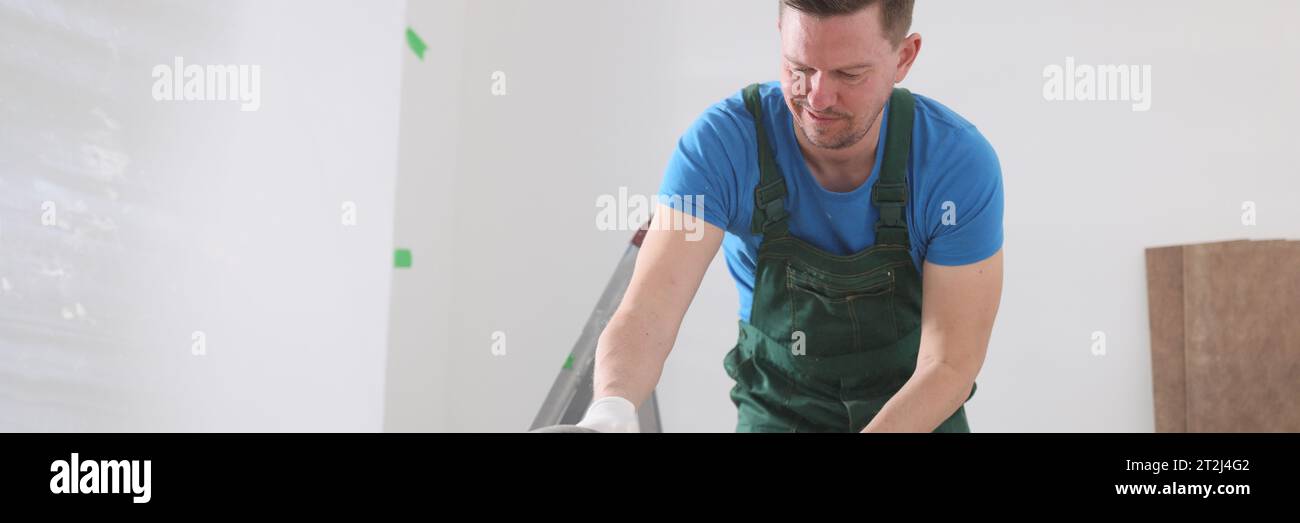 Il falegname lucida la tavola in legno con una moderna smerigliatrice Foto Stock