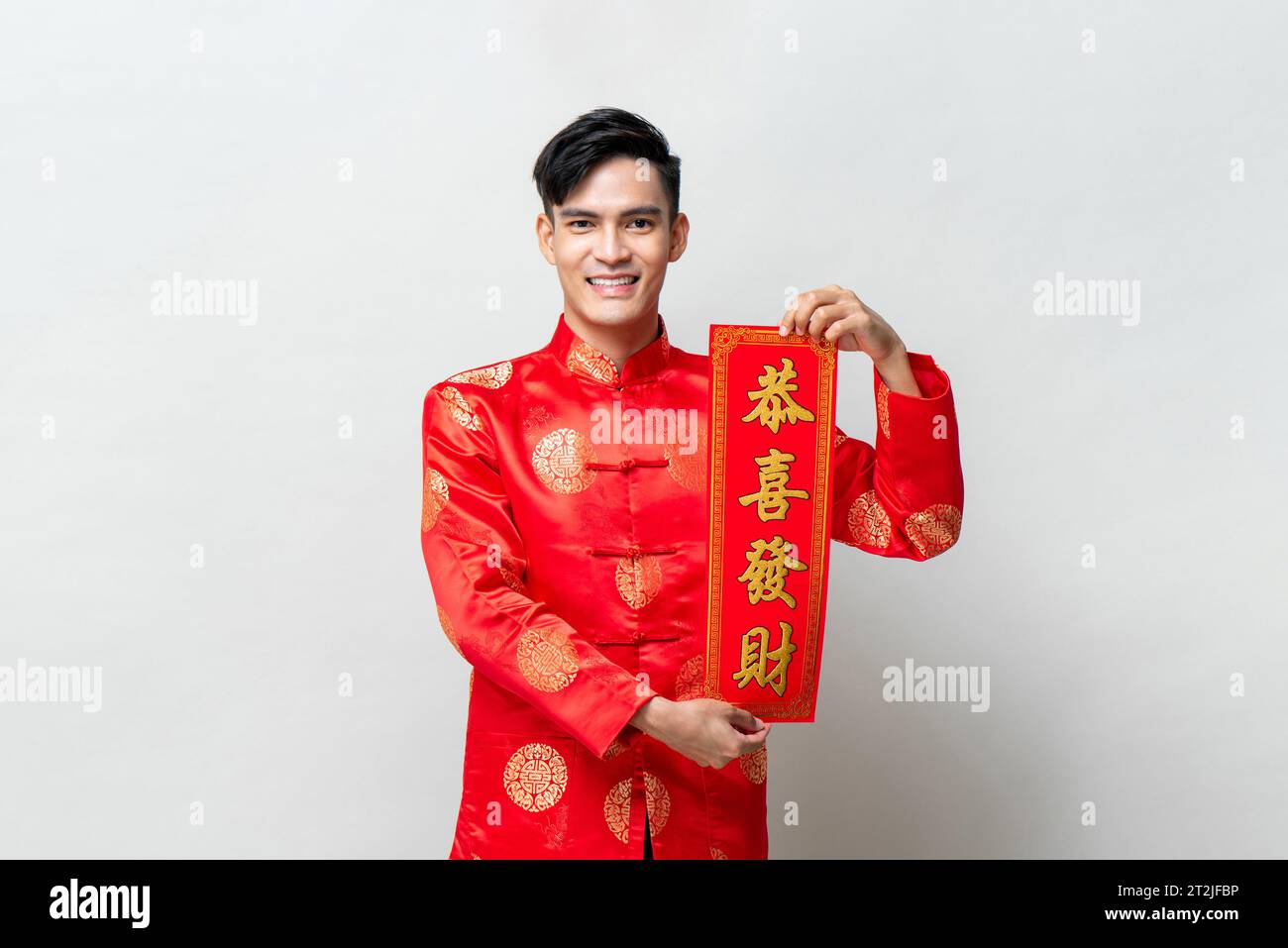 Bellissimo uomo asiatico sorridente che mostra un rotolo rosso in studio isolato sfondo grigio chiaro per i concetti del capodanno cinese, testo straniero significa "potrebbe tu atta" Foto Stock Bellissimo uomo asiatico sorridente che mostra un rotolo rosso in studio isolato sfondo grigio chiaro per i concetti del capodanno cinese, testo straniero significa "potrebbe tu atta" Foto Stock