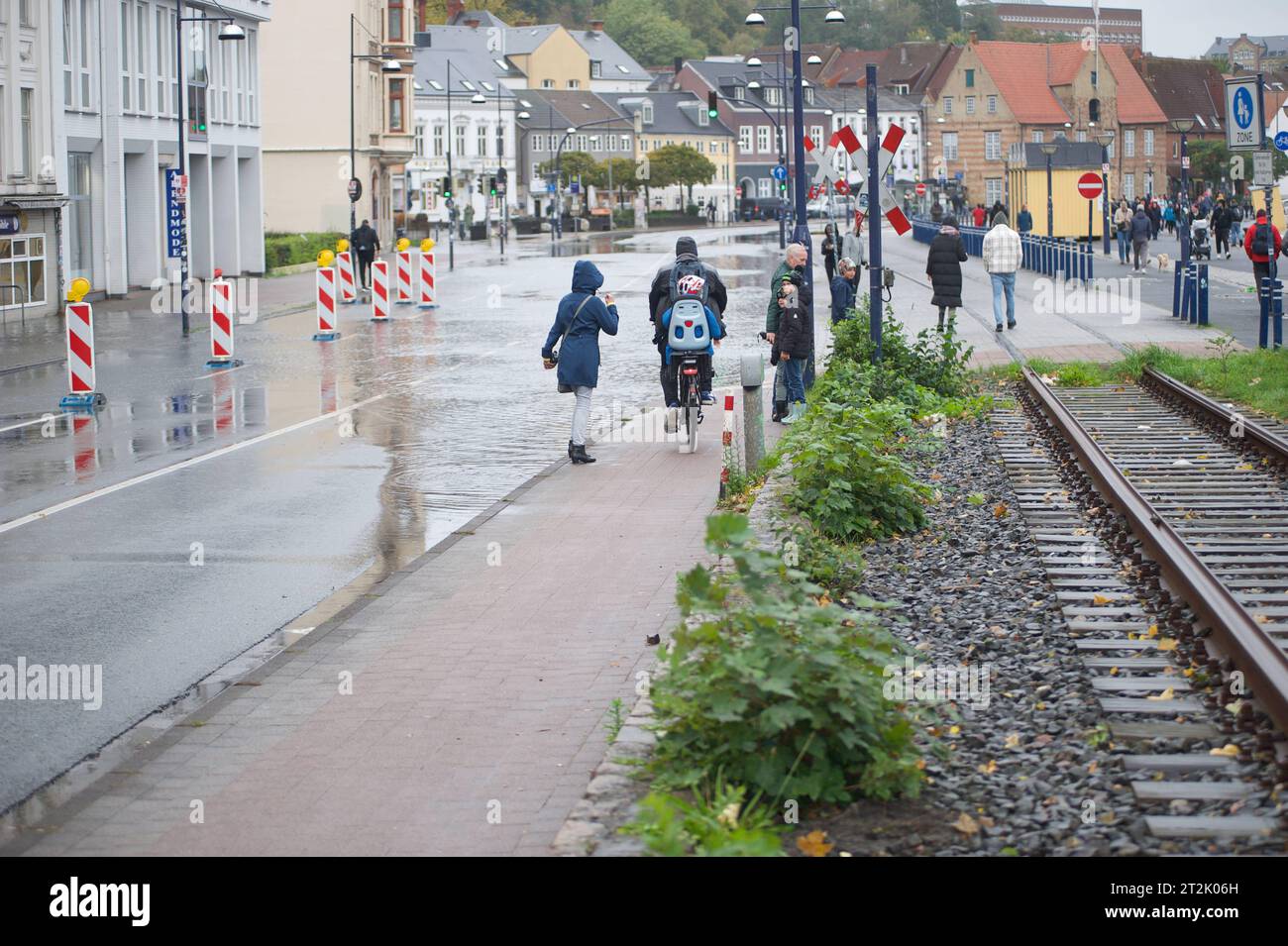 Flensburg, Schleswig-Holstein, Hochwasser in Flensburg am Hafen West, Hier: Schiffbrücke, Blick Richtung Norden, zahlreiche Schaulustige sind unterwegs per Fuß oder Fahrrad. Aufnahme vom 19.10.2023. *** Flensburg, Schleswig Holstein, alta acqua a Flensburg, a ovest del porto, qui ponte delle navi, vista a nord, numerosi spettatori sono in viaggio a piedi o in bicicletta foto scattata il 19 10 2023 Foto Stock