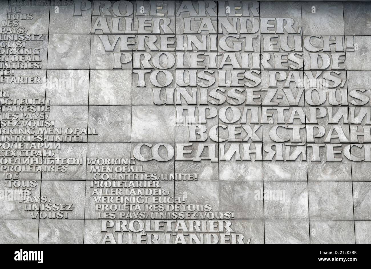 DEUTSCHLAND, Sachsen, Chemnitz, in DDR Zeiten ehemals Karl-Marx-Stadt, Hauswandrelief mit slogan Proletarier aller Länder vereinigt Euch aus Marx Schrift Kommunistisches Manifest in verschiedenen Sprachen, hinter Karl-Marx-Monument Foto Stock