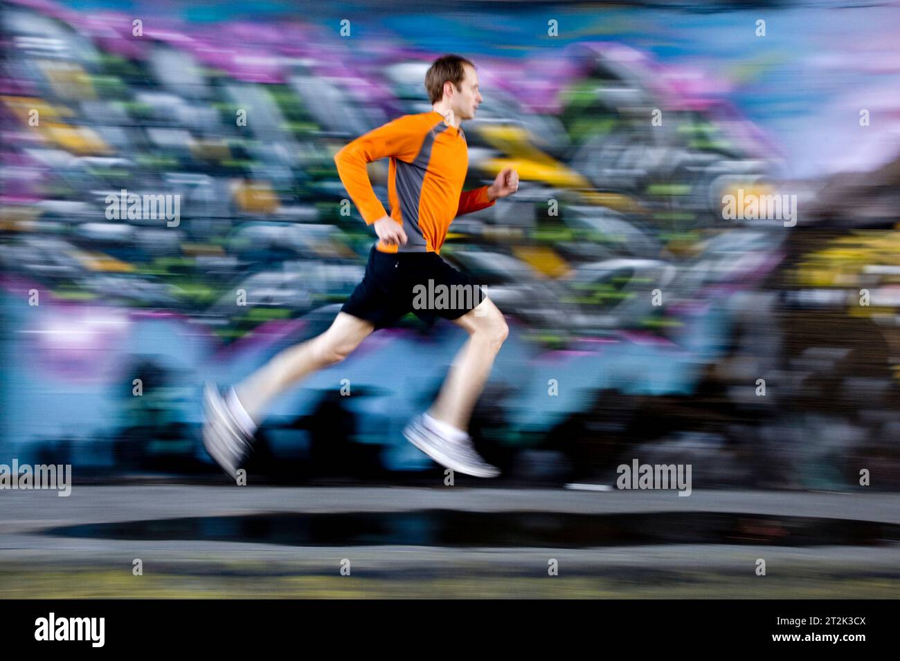Un uomo in fuga di prima mattina nelle zone industriali della città. Foto Stock