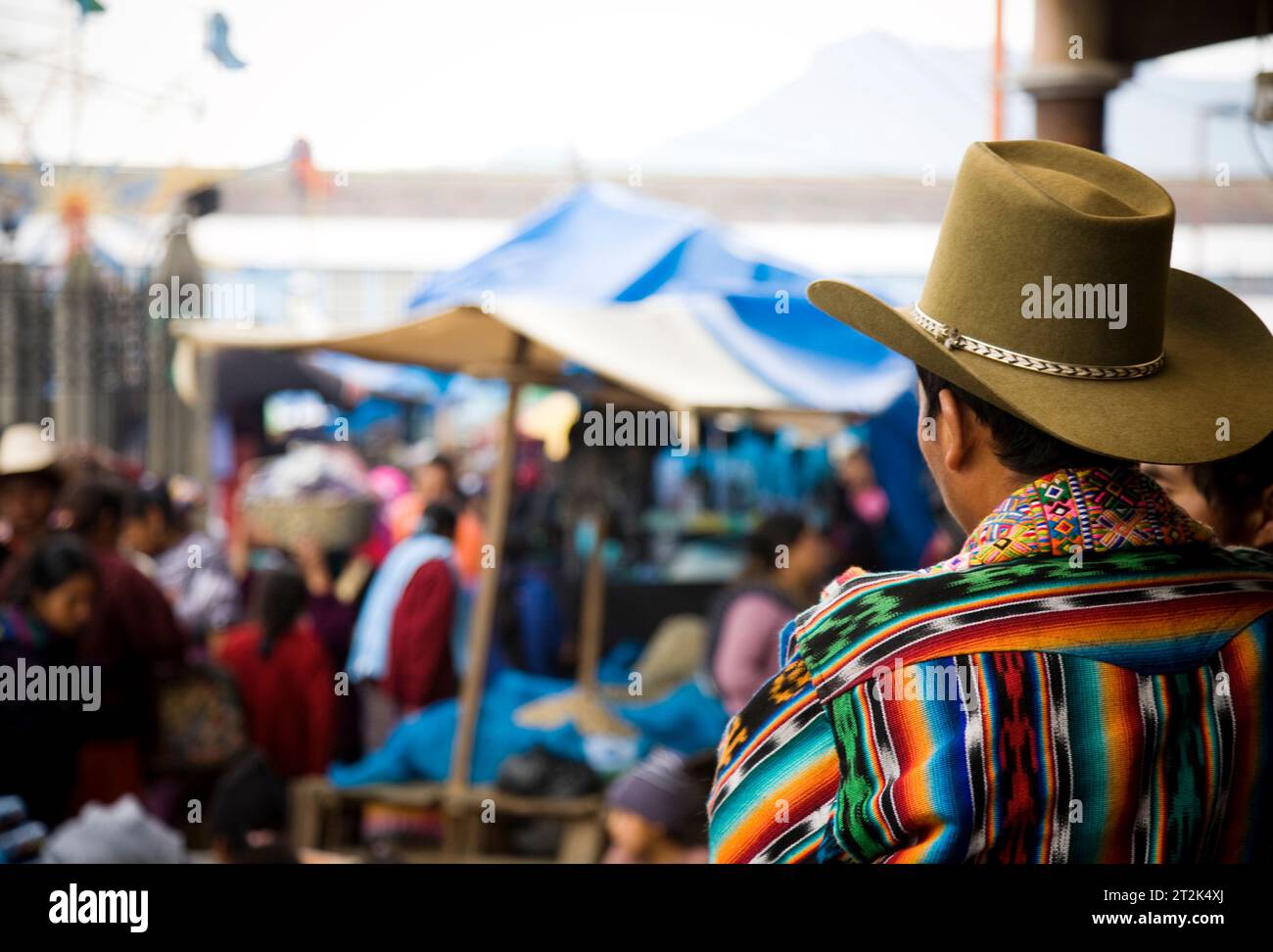 Un uomo che indossa un cappello da cowboy si affaccia su un mercato a Nahuala, in Guatemala. Foto Stock