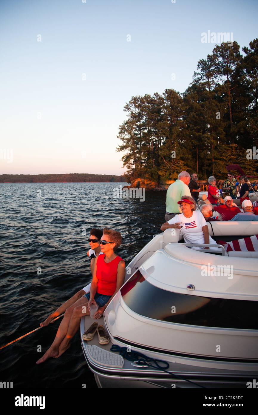 Una comunità di persone che vivono tutti su un lago legano le loro barche per una festa in una serata di sole. Foto Stock