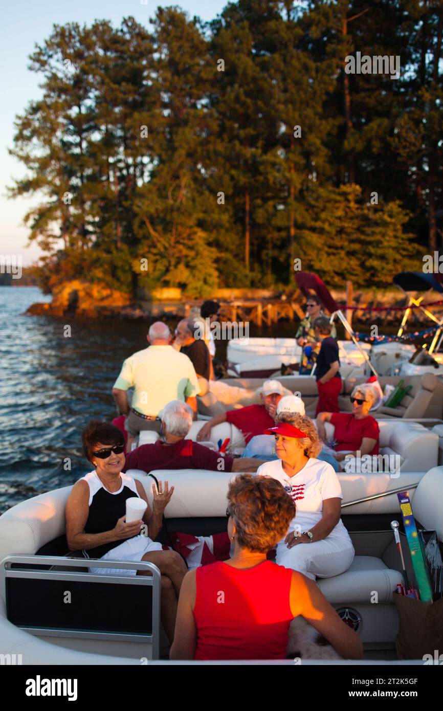 Una comunità di persone che vivono tutti su un lago legano le loro barche per una festa in una serata di sole. Foto Stock