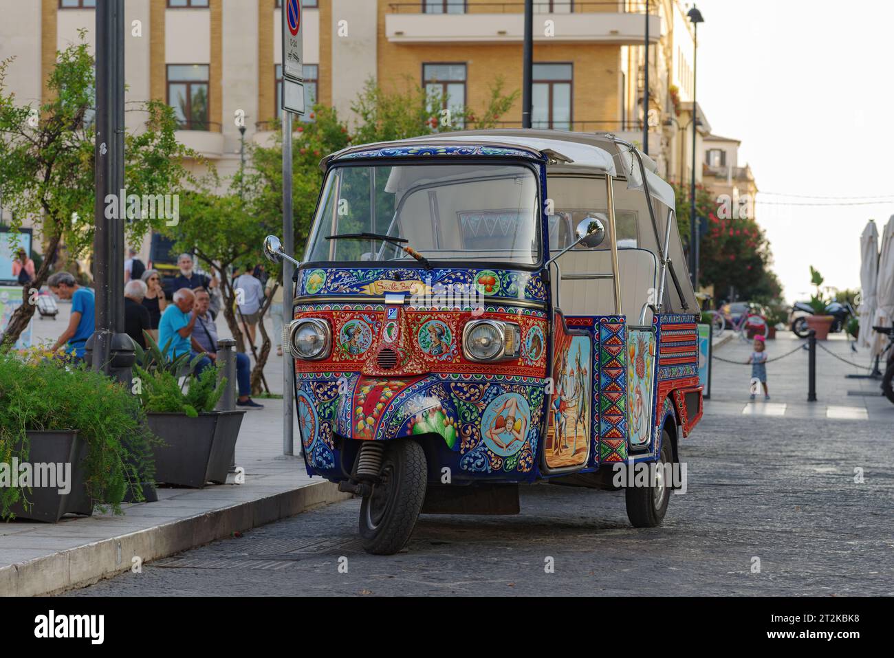 Piaggio Ape veicolo dipinto con motivi tradizionali siciliani, parcheggiato in una strada nella storica Ortigia, Sicilia. Foto Stock