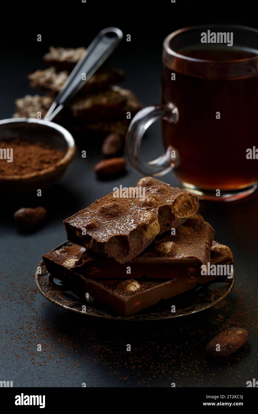 Pezzi di cioccolato e cacao in polvere. Fette di cioccolato, concetto fotografico Sweet food. Foto Stock