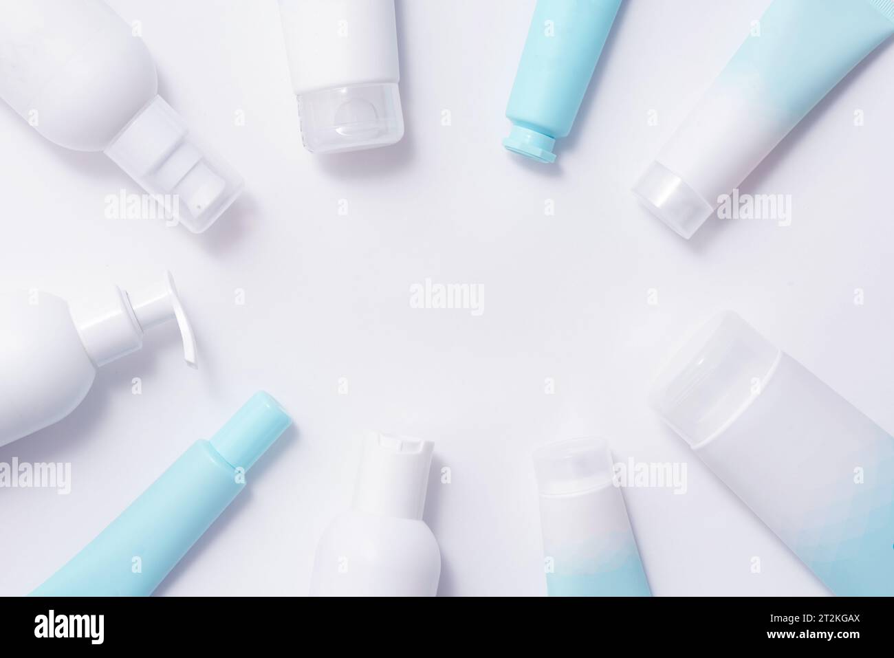 Bottiglie e provette con prodotti cosmetici su sfondo blu morbido Foto Stock
