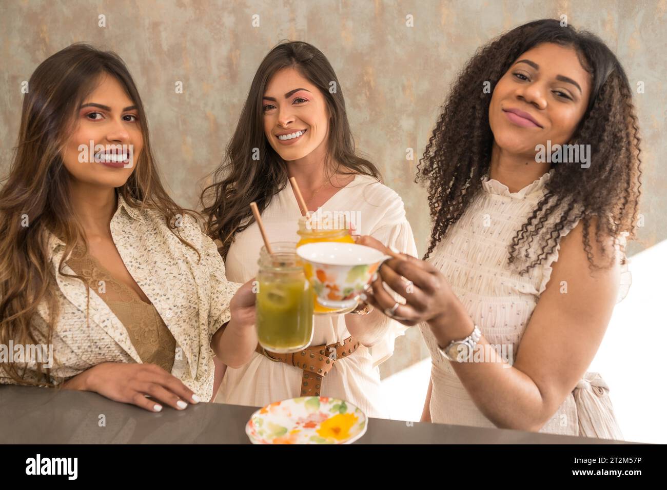 Donna che tosta e festeggia con succhi di frutta e tè Foto Stock