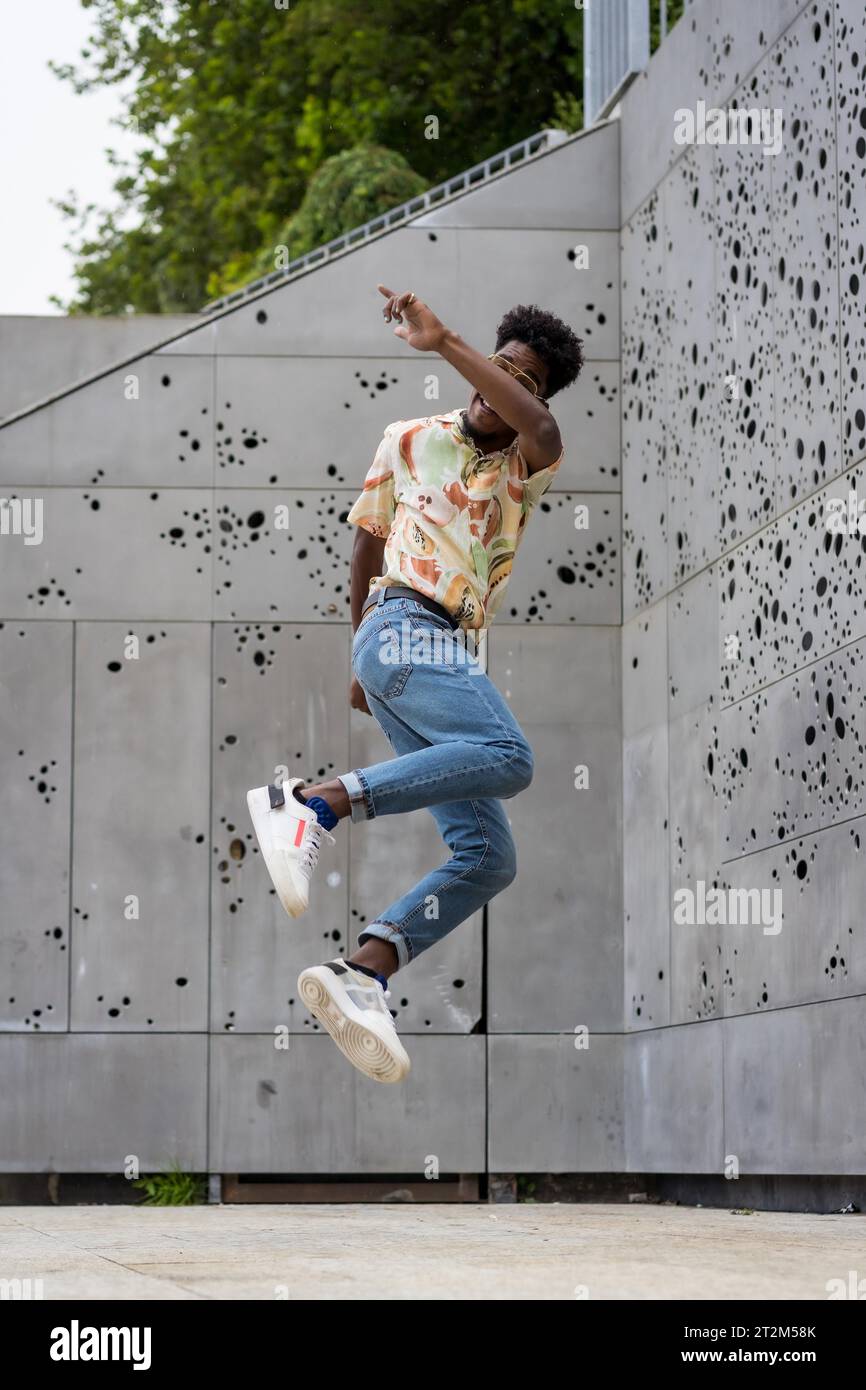 Foto verticale di un uomo afro-americano che salta in alto all'aperto Foto Stock