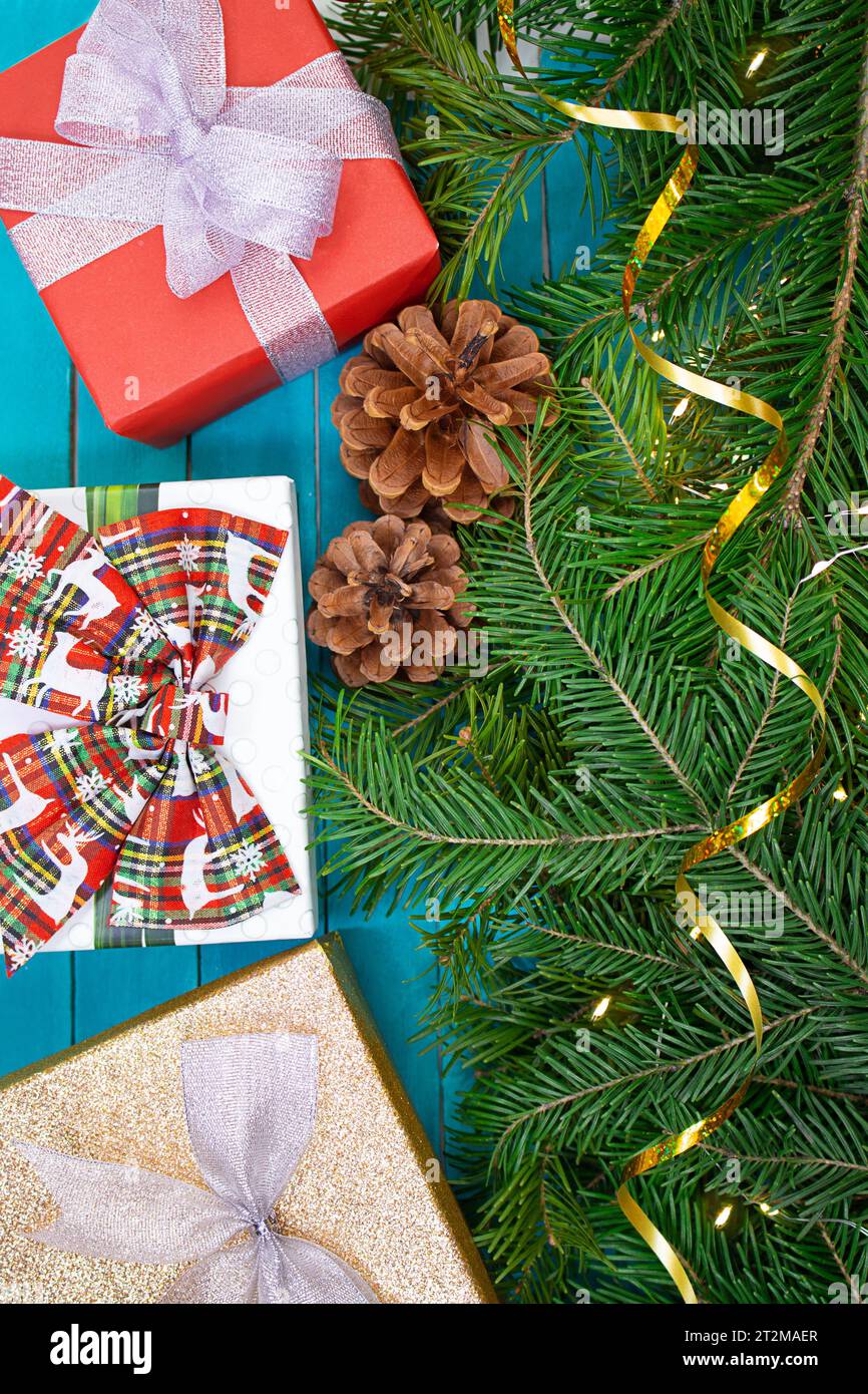 Sfondo natalizio. Confezioni regalo con fiocchi con rami di abete e luci. Vista dall'alto. Natale, Capodanno, compleanno, festività, saldi, spianatura piatta. Saluto Foto Stock