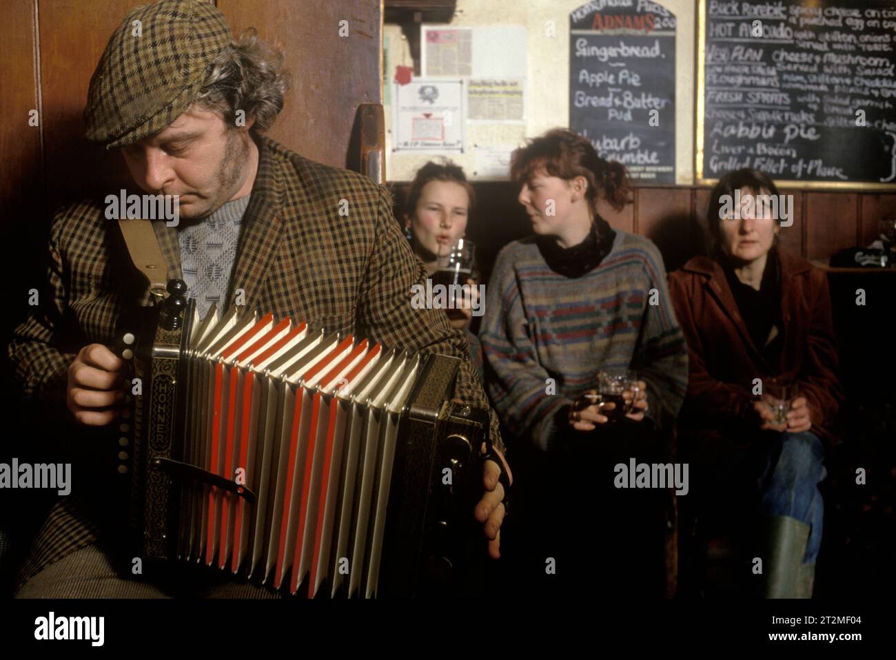 Musica folk tradizionale Regno Unito anni '1980 Contadini e amici, sta suonando un melodeon al Kings Head, e conosciuto anche come il pub Low House di Laxfield. Le canzoni di musica folk vengono eseguite in modo informale ogni domenica mattina. Laxfield, Suffolk, Inghilterra, HOMER SYKES anni '1985 1980 Foto Stock