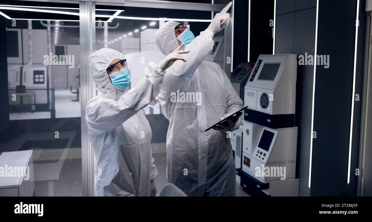 Fabbrica di produzione di semiconduttori sterile e lavoratori in tute Foto Stock