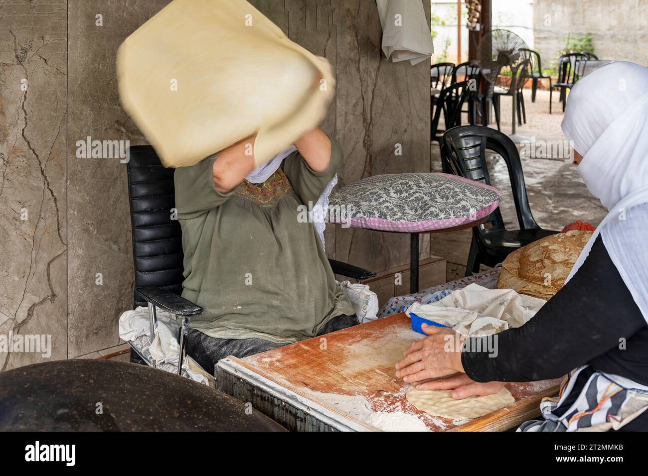 Hurfeish, Israele - 14 agosto 2023: Due donne curde preparano pita fresca in un ristorante curdo a Hurfeish, nel nord di Israele. Foto Stock