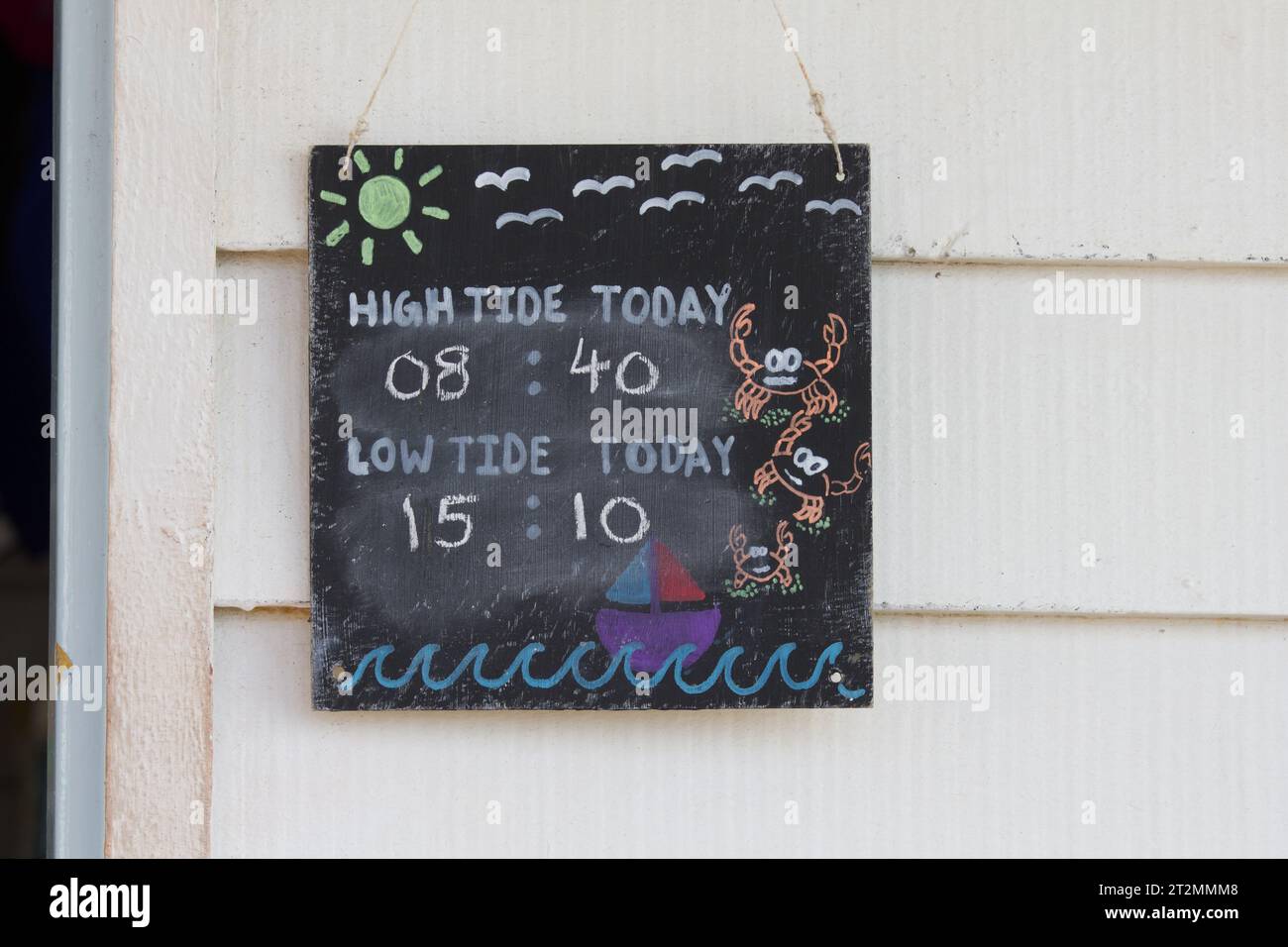 Cartello che avvisa i turisti di maree basse e alte in una spiaggia. Tempi di marea. Per informazioni e consigli sulla sicurezza per le persone che non stanno attenti. Foto Stock
