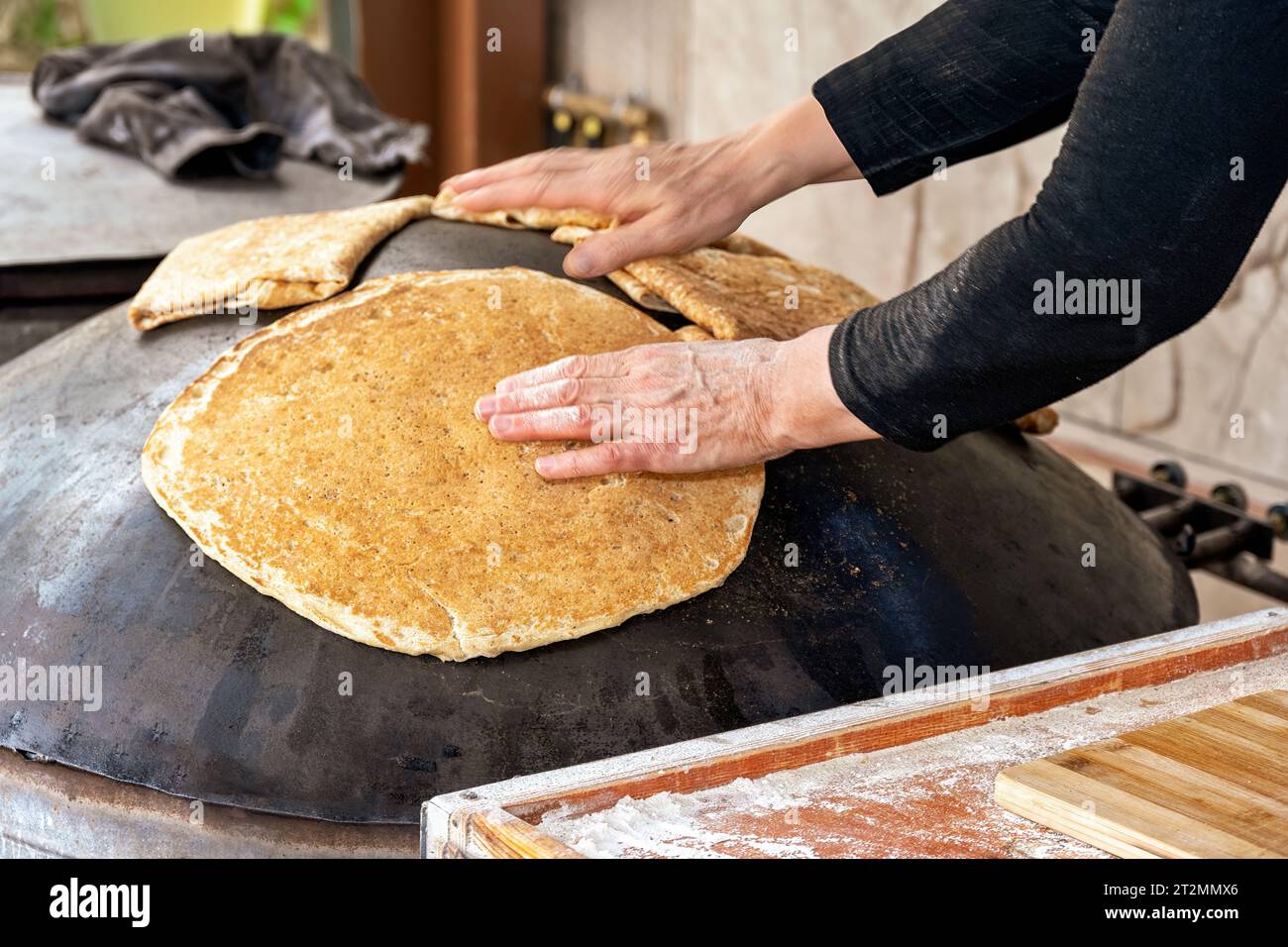 Donna curda che prepara pita fresca in un ristorante curdo a Hurfeish, nel nord di Israele. Cuocere pita sul gridle. Foto Stock