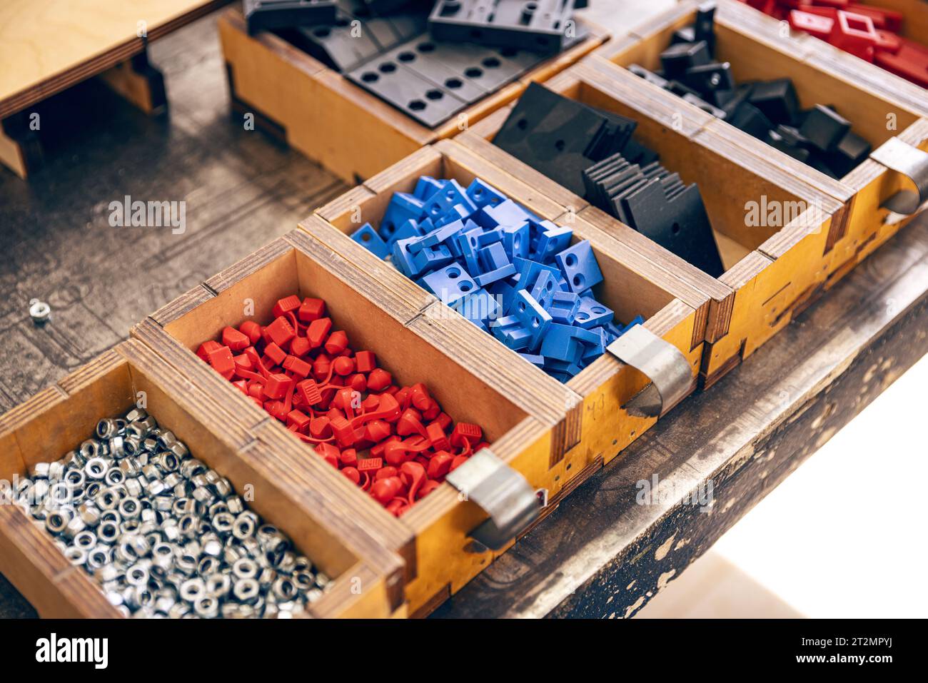 Scatole in legno con divisori contenenti dadi metallici e forme in plastica Foto Stock