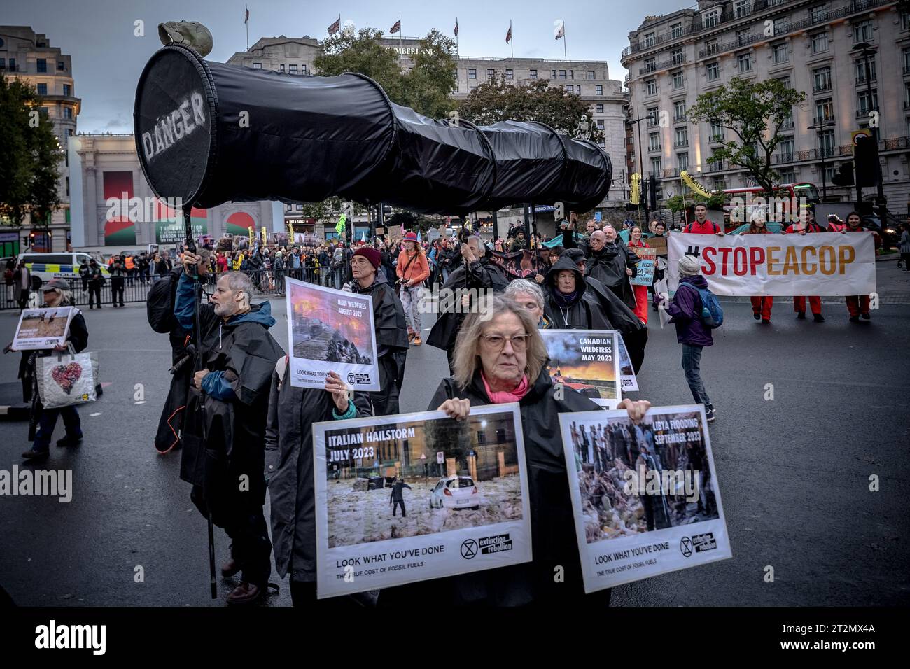 Londra, Regno Unito. 19 ottobre 2023. Un gigantesco oleodotto simulato viene condotto durante la protesta climatica "Oily Money Out" da parte di attivisti della Fossil Free London prima di marciare da Marble Arch all'Intercontinental Hotel Park Lane per chiedere cambiamenti nell'industria dei combustibili fossili. All'Intercontinental Hotel Park Lane si terrà un Energy Intelligence Forum di tre giorni (precedentemente Oil and Money Conference), al di fuori del quale si sono svolte proteste per questa settimana. Crediti: Guy Corbishley/Alamy Live News Foto Stock