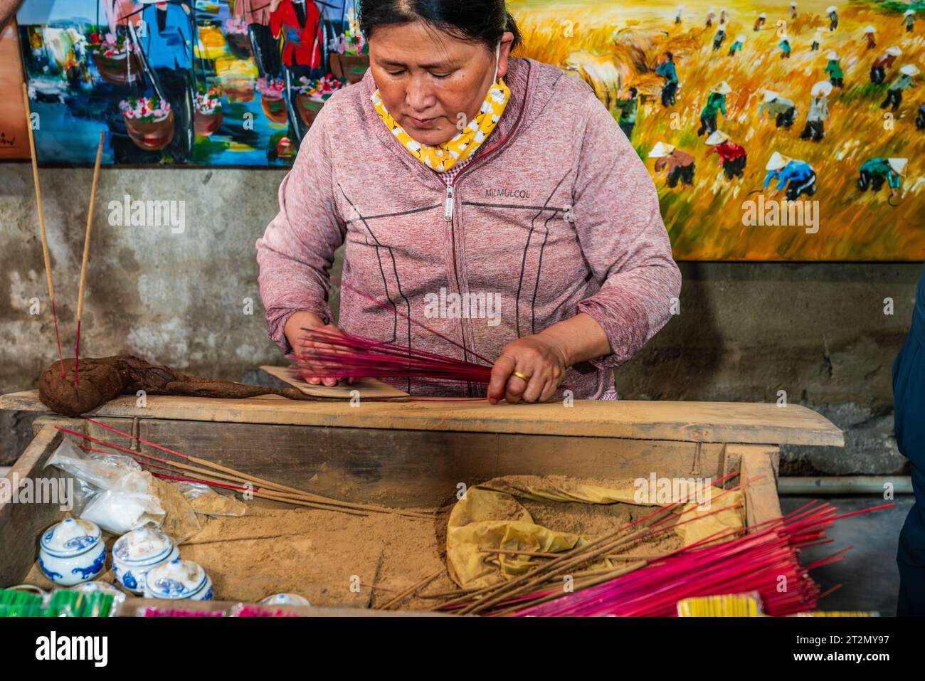 Hue, Vietnam, 18 novembre 2022: La donna locale sta preparando bastoncini di incenso in un negozio di Hue, Vietnam Foto Stock