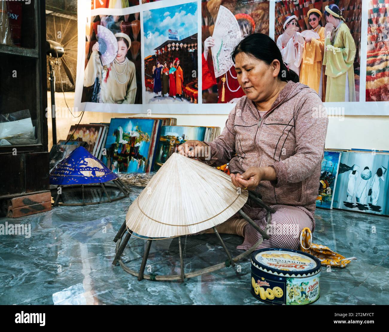 Hue, Vietnam, 18 novembre 2022: Una donna sta facendo cappelli conici vietnamiti tradizionali in un negozio a Hue, Vietnam Foto Stock